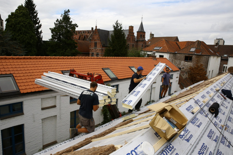 Dakwerkers leggen isolatie op een rijhuis