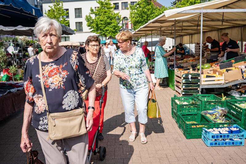 Enkele dames van leeftijd doen boodschappen op de markt