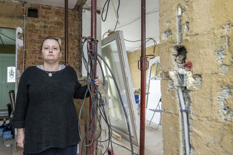 Een vrouw staat in haar half afgewerkte garage