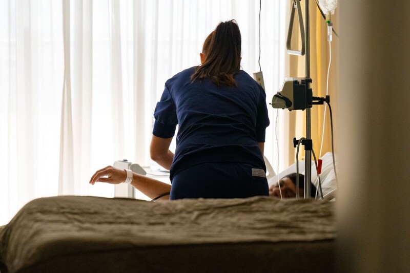 Een verpleegkundige verzorgt een patiënt in het ziekenhuis.