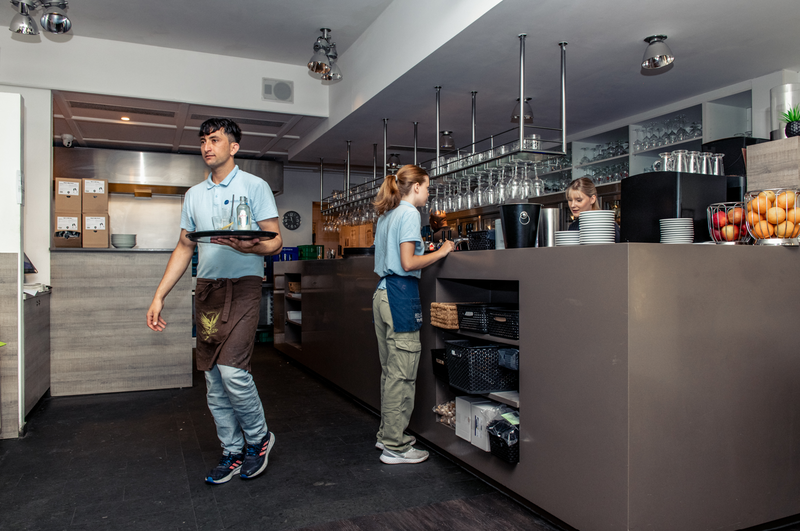 Twee kelners zijn aan het werk in een horecazaak