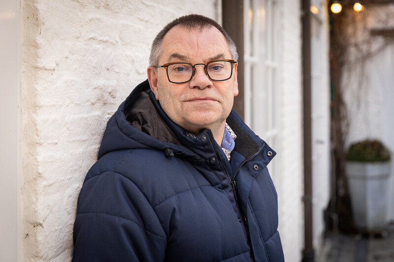 Secretaris van ACV bouw, industrie en energie Johan Quintelier staat geposeerd voor een witte muur.