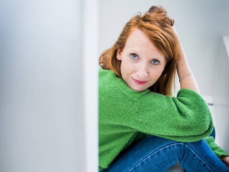 Linde Merckpoel zit op de grond en kijkt in de camera