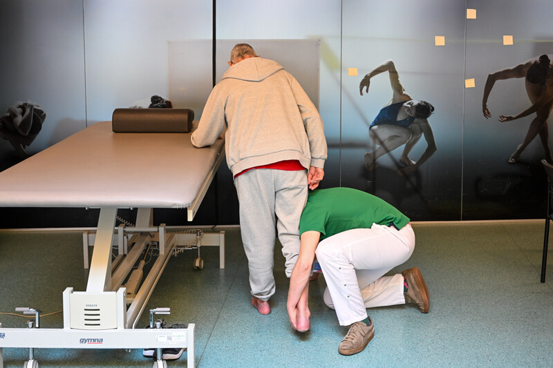 Een kinesist helpt een patient in het ziekenhuis bij een revalidatie