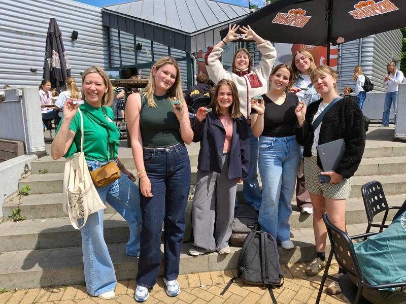 Op de trappen van het Beverse jeugdhuis Togenblik poseren een 6-tal studentes met een pakje kauwgum in de hand.