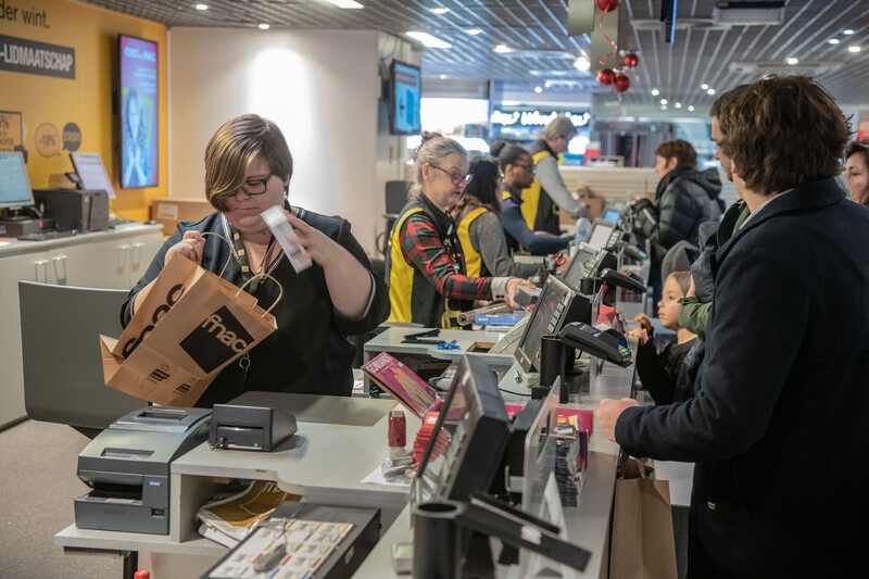 Rij kassamedewerkers van winkelketen Fnac bezig met het afrekenen van boodschappen van klanten