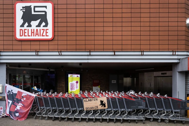 staking Delhaize filiaal ingang geblokkeerd met winkelkarretjes