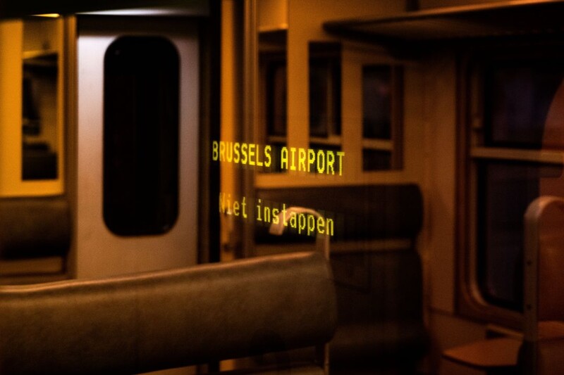 We zien een donkere en lege treincoupé, de trein houdt halt in Brussels airport.