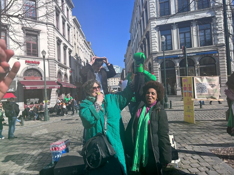 Vrouw houdt bokshandschoen triomfantelijk omhoog tijdens vakbondsactie