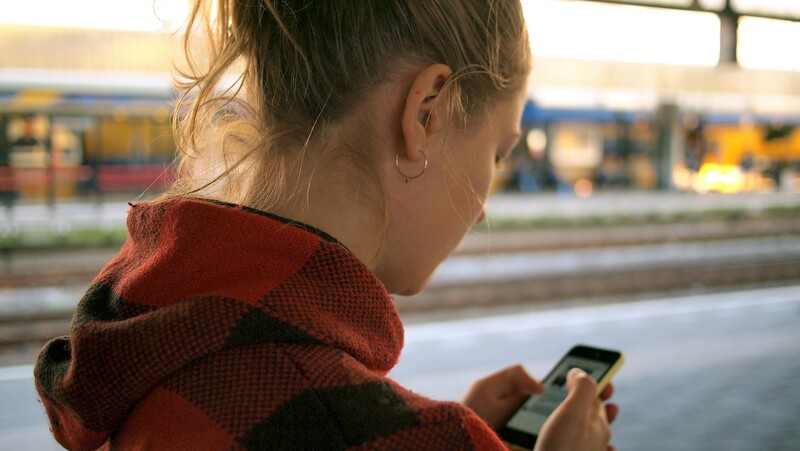 Jonge vrouw scrollend op haar smartphone