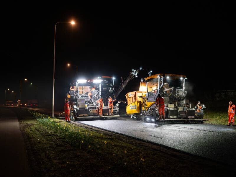 arbeiders wegenbouw vernieuwen wegdek tijdens nachtshift
