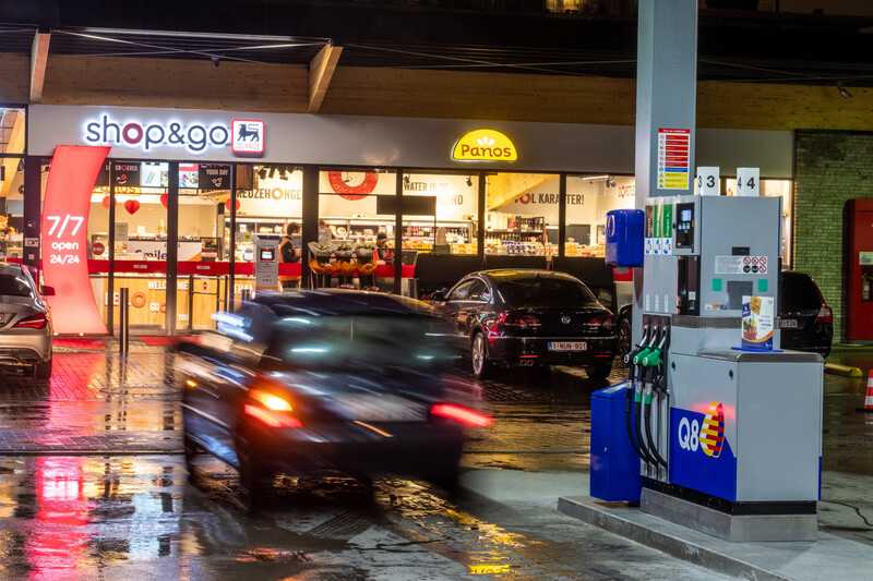 winkel aan tankstation tijdens de nacht met een banner "7/7 en 24/24 open"