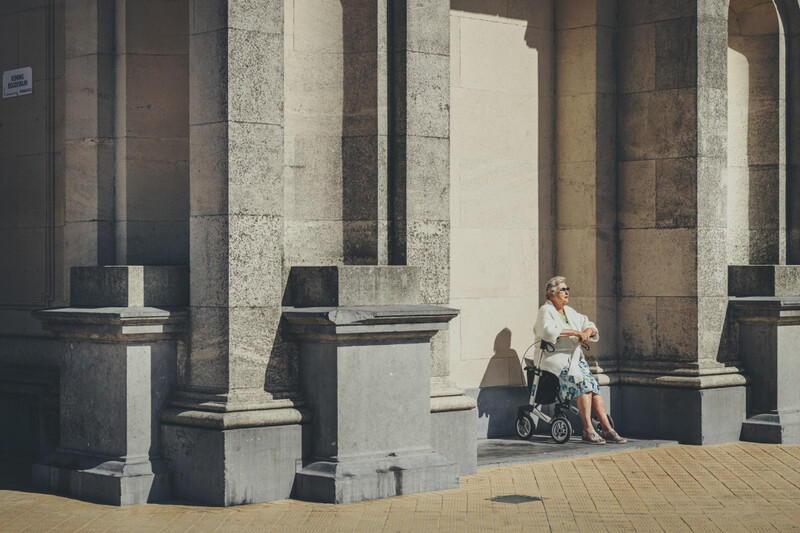 Oudere vrouw op rollator aan het zonnen in Oostende