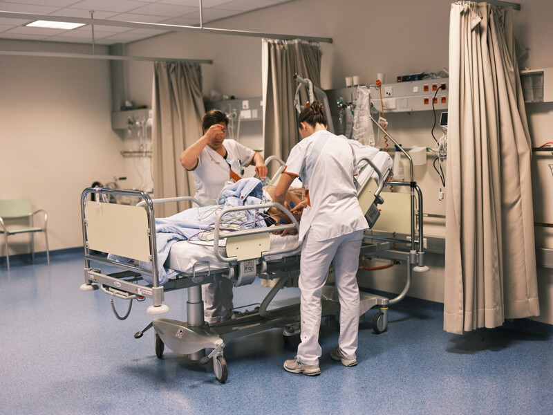 Verpleegkundigen verzorgen patiënt in ziekenhuisbed