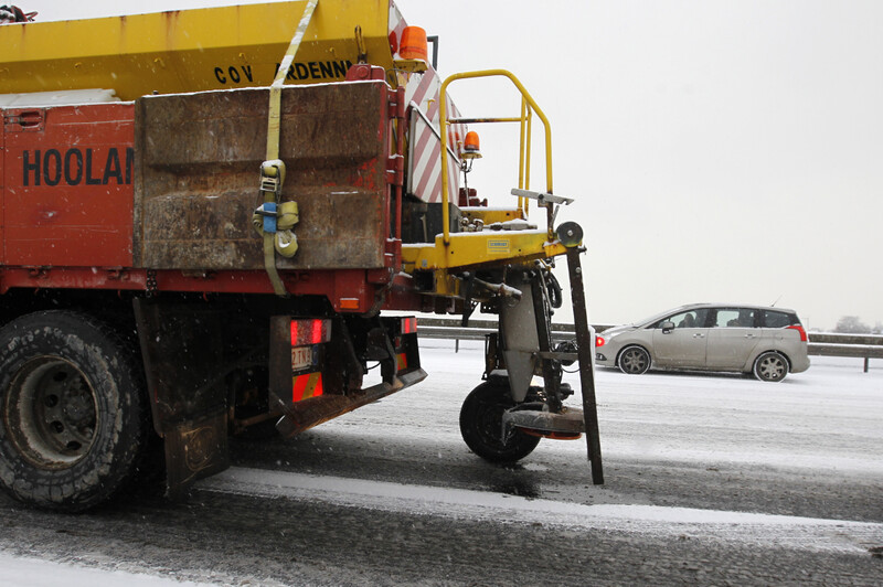 Strooiwagen op besneeuwde snelweg
