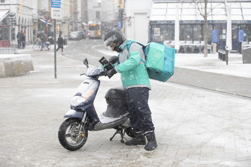 Deliveroo-koerier in de sneeuw in Brugge