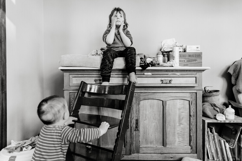 wanhopige thuissituatie met een kind op de kast, een ander kind onderweg met een stoel