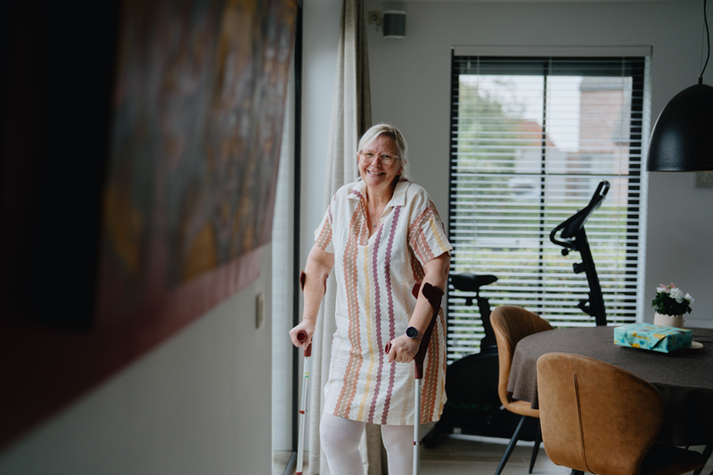 Nancy Wittevrongel, op krukken in haar woonruimte