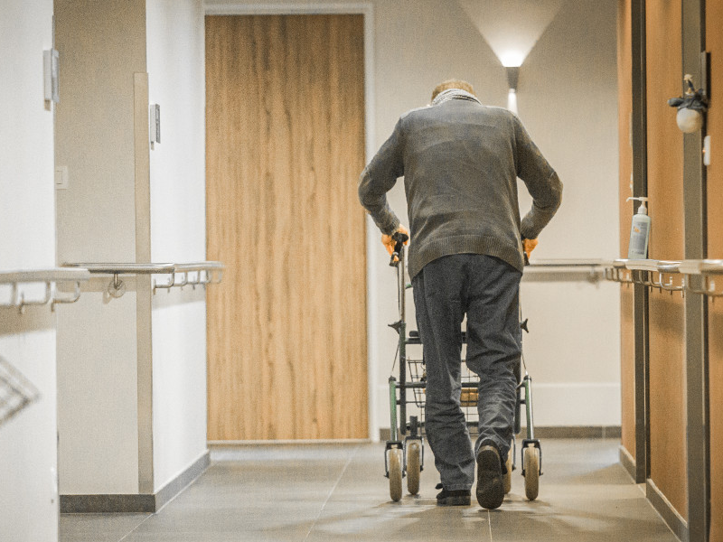 Oude man wandelt door gang