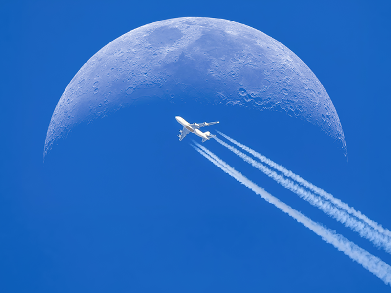 Vliegtuig dat voor de maan vliegt