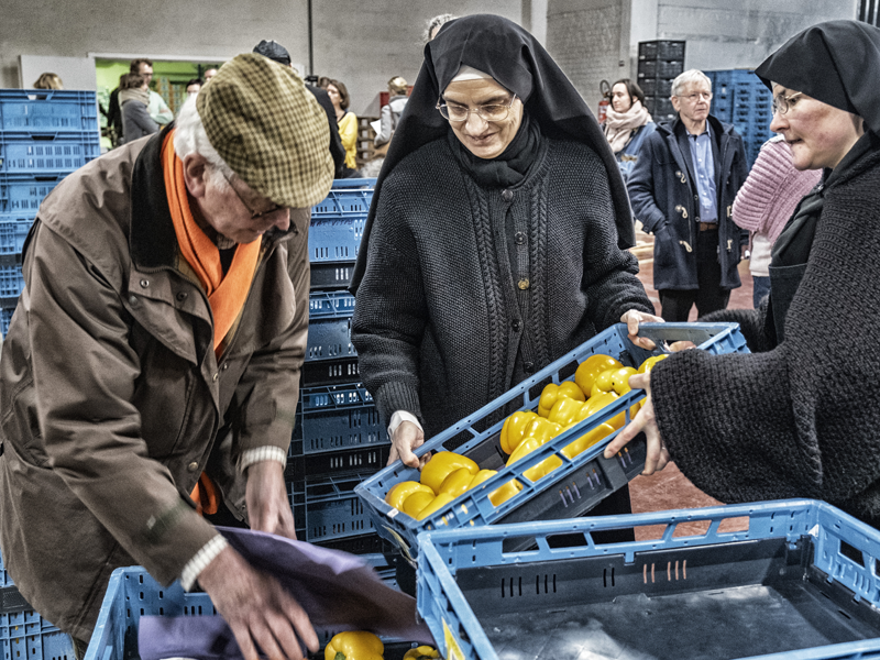 Nonnen helpen man met eten in voedselbank