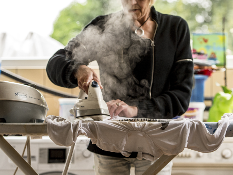 Een huishoudhulp strijkt een hemd