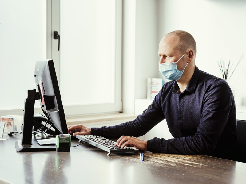 Een huisarts achter zijn computer