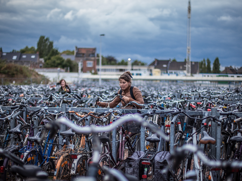 Dame neemt fiets aan volle fietsenparking aan achterkant station Gent Sint-Pieters