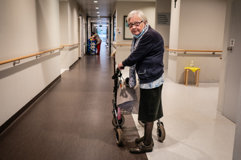 Oudere dame met rollator in woonzorgcentrum