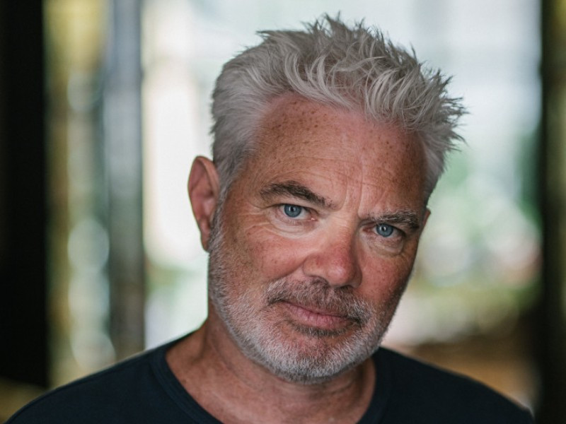 Portret van Stany Crets voor oude glazen deur