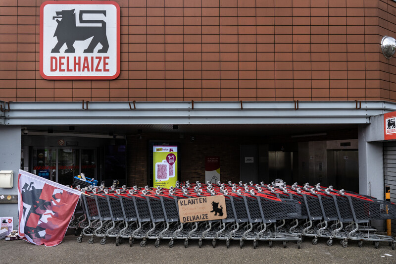 Winkelkarren met pancartes versperren de ingang van de Delhaize supermarkt in Gent Ledeberg
