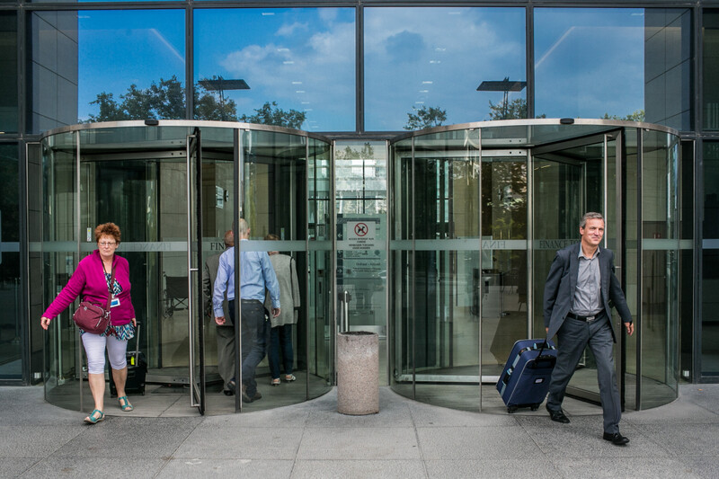 Ambtenaren wandelen door draaideuren aan Finance Tower in Brussel