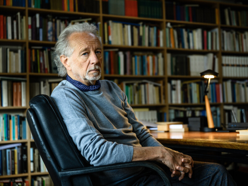 Stefaan Hertmans op stoel in bibliotheek