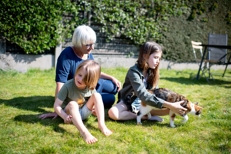 Grootmoeder speelt met kleinkinderen in tuin