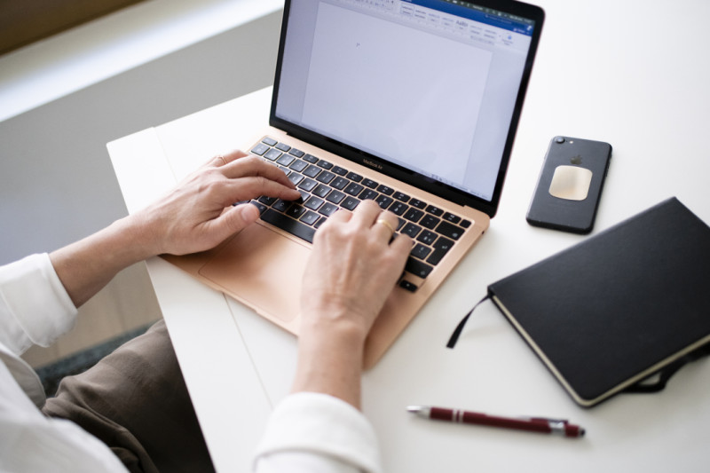 Stockbeeld van persoon die aan het thuiswerken is op laptop