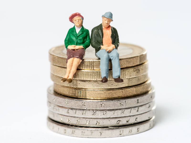 Ouder koppel dat zit op een stapel euromunten