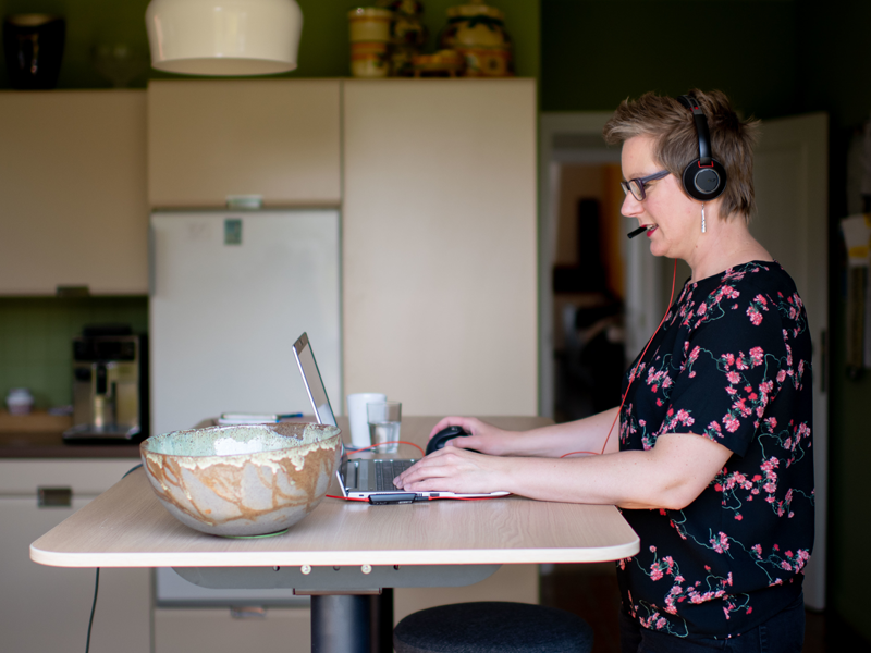 Vrouw werkt aan keukentafel