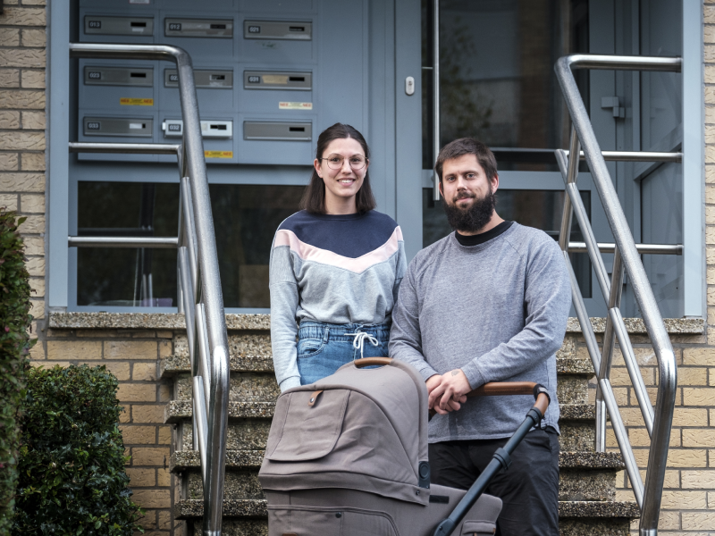 Gezin voor woning met kinderkoets