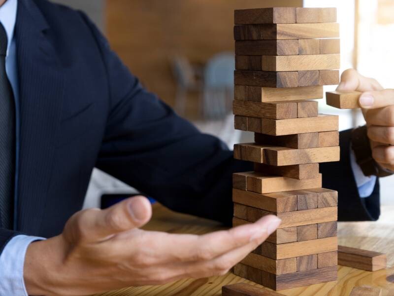 Man in kostuum speelt Jenga