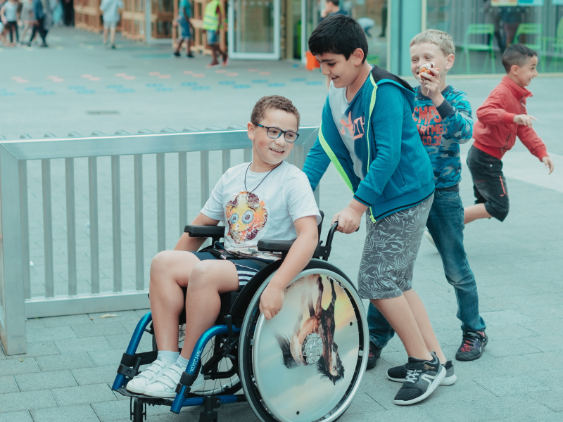 Kinderen op de speelplaats, een jongen in een rolstoel