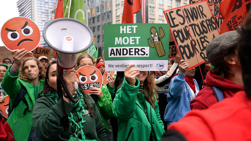 groep mensen op betoging met borden en megafoon