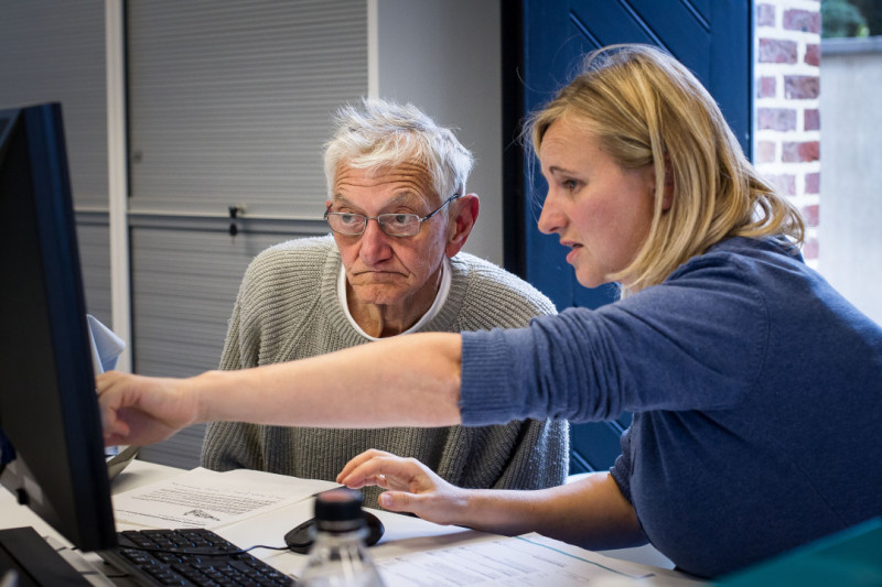 Oudere man wordt geholpen door ambetanaar.